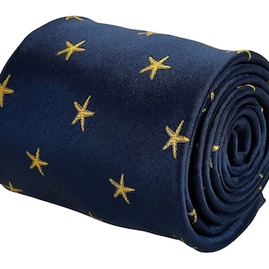 Könnte beinhalten: Eine marineblaue Krawatte mit einem sich wiederholenden Muster aus goldenen Seesternen.