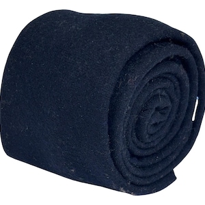 May include: A rolled-up, navy blue tie. The tie is made of a soft, textured fabric and is tightly rolled, showcasing its shape and material. The dark color suggests a formal or professional style.