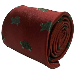May include: A red silk tie with a repeating pattern of green turtles. The tie is rolled up and ready to be worn.