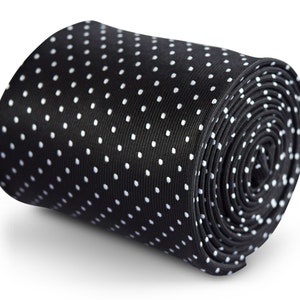 May include: A black necktie with white polka dots. The tie is rolled up.