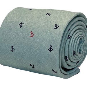 Puede incluir: Una corbata azul claro enrollada con fondo blanco y un patrón de pequeñas ancres rojas y azul marino.