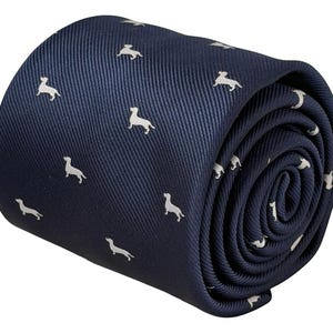 Può includere: Una cravatta blu navy arrotolata a forma di cilindro, caratterizzata da un motivo ripetitivo di piccole sagome bianche di bassotti stilizzati distribuite uniformemente sulla superficie del tessuto, che presenta una visibile trama a coste diagonali.