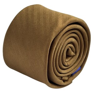 May include: A rolled-up tie in a warm, golden-brown colour. The tie has a subtle herringbone pattern, adding texture to the fabric. A small blue tag is visible at the end. The tie is tightly rolled, showcasing its shape and design.