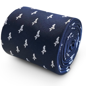 May include: Rolled navy blue tie with a repeating white pattern of stylized fish. The tie is tightly rolled, showcasing the pattern and the fabric's texture. The design is simple and elegant, suitable for formal or semi-formal occasions.