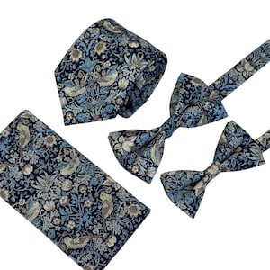 Può includere: Un set di tre accessori per il collo con un motivo floreale blu e crema. Il set comprende una cravatta, un papillon e un fazzoletto da taschino.