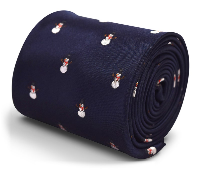 Puede incluir: Una corbata azul marino con un patr&oacute;n repetido de mu&ntilde;ecos de nieve blancos. Los mu&ntilde;ecos de nieve tienen sombreros negros, narices naranjas y bufandas rojas.