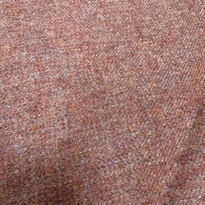 May include: A close-up view of a woven fabric featuring a dense herringbone pattern. The textile displays a blend of earthy tones, including shades of rust, burnt orange, muted brown, and subtle flecks of grey, creating a textured appearance.