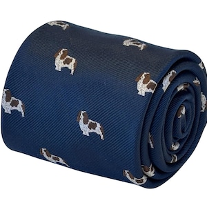 May include: A navy blue tie with a repeating pattern of brown and white dogs. The tie is rolled up and ready to be worn.