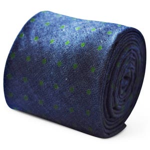 Op de afbeelding: Een opgerolde blauwe stropdas met een groen stippenpatroon.