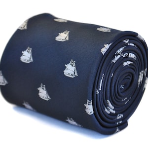May include: A navy blue silk tie with a white sailboat pattern. The tie is rolled up and ready to be worn.