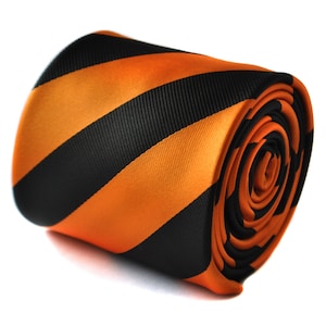 May include: A rolled orange and black striped tie. The tie is made of a silky material and has a diagonal stripe pattern.