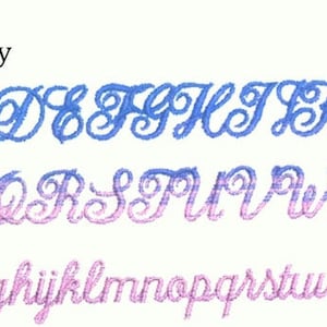 May include: A cursive font alphabet in blue, purple, and pink. The word "Anniversary" is above the alphabet. The uppercase letters are blue, the middle row is purple, and the lowercase letters are pink.