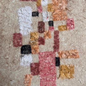 May include: Abstract art rug with a beige background and colorful geometric shapes in shades of red, orange, yellow, and white.