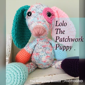 May include: A crocheted patchwork puppy toy named "Lolo The Patchwork Puppy". The toy is made of various colors of yarn, including pink, blue, green, and orange. The puppy has large, black eyes and a pink nose.