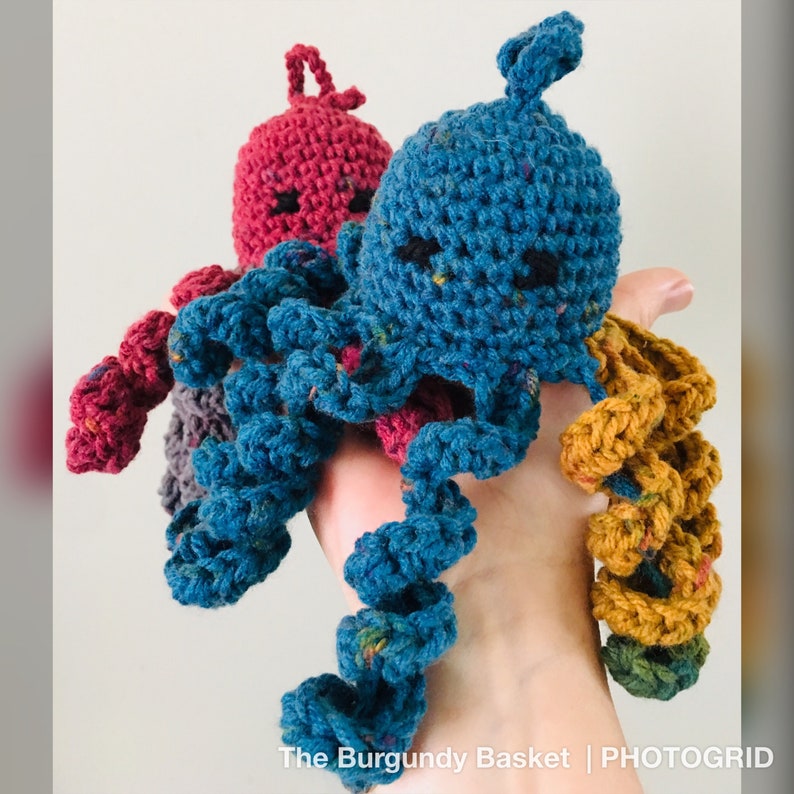 May include: Two crocheted octopus plushies. One is blue with a speckled pattern and the other is red with a speckled pattern. Both have black eyes and a white mouth.