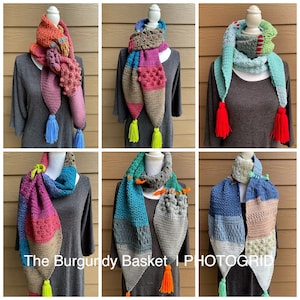 May include: Six colorful crocheted scarves with tassels. The scarves are made with different colors of yarn and have a variety of patterns. The scarves are displayed on mannequins wearing gray shirts.