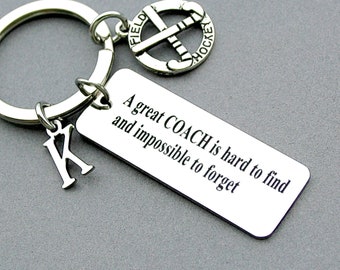 May include: Silver keychain with a hockey stick charm, a letter K charm, and a tag that reads "A great COACH is hard to find and impossible to forget."