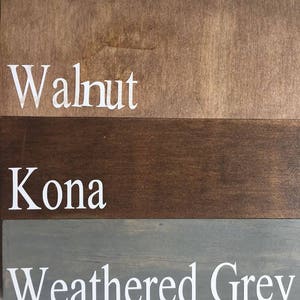 May include: Three wooden planks with different stain colors. The top plank is walnut, the middle plank is Kona, and the bottom plank is weathered gray. Each plank has the color name printed in white.