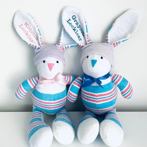 May include: Two personalized striped bunny plush toys. The blue and pink striped bunny has a pink bow and the name "Kristin Locklear" embroidered on the ear. The blue and pink striped bunny has a blue bow and the name "Grayson Locklear" embroidered on the ear.