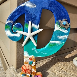 Large P ocean wall art with natural shells, sand, blue starfish plumeria flower, colored shell pieces, Sea turtles, and large starfish, art