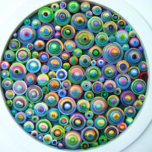 Puede incluir: Una pieza de arte de pared circular hecha de c&iacute;rculos de papel de colores, dispuestos en un patr&oacute;n conc&eacute;ntrico. Los c&iacute;rculos son de varios tama&ntilde;os y tonos de azul, verde, amarillo, rojo y morado.