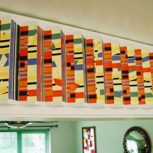 May include: A colorful geometric pattern with alternating stripes of red, yellow, black, blue, and green. The pattern is repeated in a series of vertical panels.