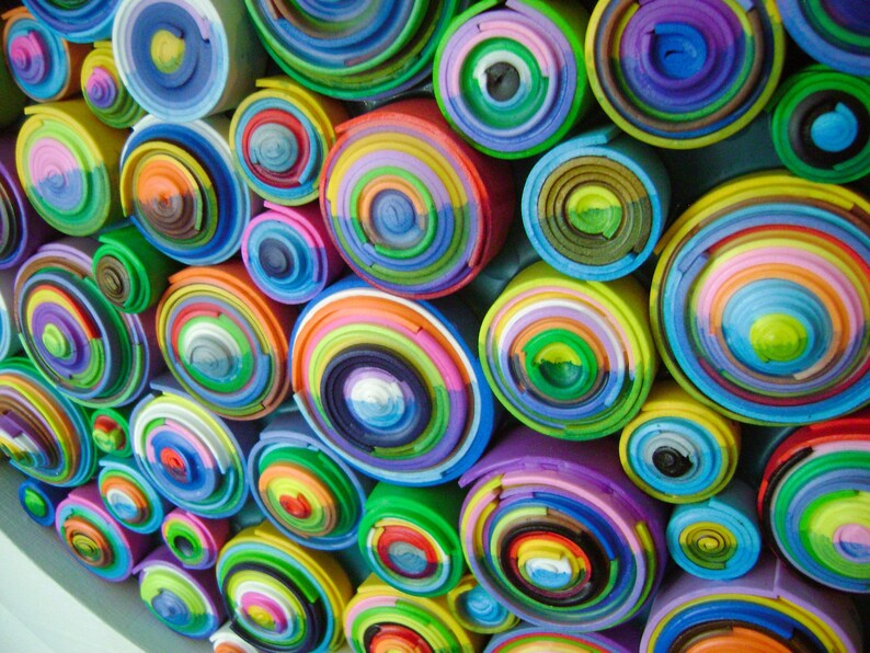 Puede incluir: Una pieza de arte de pared colorida hecha de c&iacute;rculos conc&eacute;ntricos apilados de varios colores. Los c&iacute;rculos est&aacute;n dispuestos en un patr&oacute;n aleatorio, creando un dise&ntilde;o abstracto visualmente atractivo.