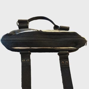 Puede incluir: Bolso tote con estampado en blanco y negro con asa superior y dos correas para el hombro. El bolso tiene cierre de cremallera y detalles de cuero. El dise&ntilde;o presenta un patr&oacute;n abstracto en blanco y negro.