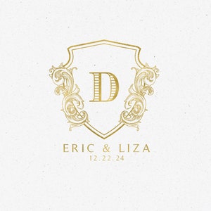 Puede incluir: Una invitación de boda dorada con un diseño de escudo decorativo que presenta la letra "D" en el centro. El texto "ERIC & LIZA" y "12.22.24" está debajo del escudo.