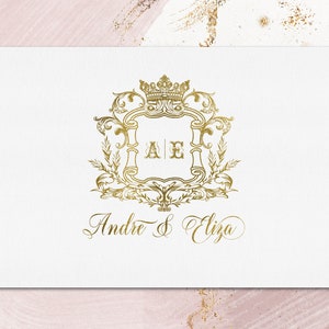 Op de afbeelding: Een gouden bruiloftsuitnodiging met een decoratief wapenschild met de initialen "A & E" en de namen "Andre & Eliza" in een handschrift.
