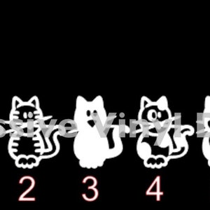 May include: White vinyl decal featuring a woman and six cat figures. Each cat has a unique design, with numbers 1-6 below them. The text "Impressive Vinyl Design" is partially visible in the background. The figures are on a black background.
