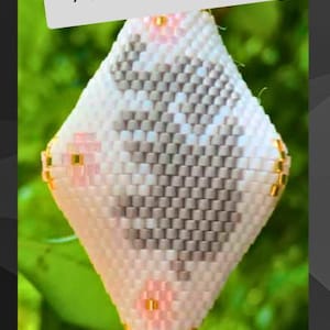 Op de afbeelding: Een ruitvormig ornament van kralen met een witte achtergrond, een grijs centraal ontwerp en roze accenten. Het stuk is versierd met kleine gouden kralen en bevat de tekst Hookin' to the Beat op een grijze banner als overlay.