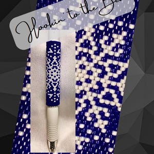 Puede incluir: Un bolígrafo blanco con un diseño de cuentas azules y blancas. El bolígrafo está decorado con un patrón de copo de nieve y las palabras "Hookin' to the Beat".