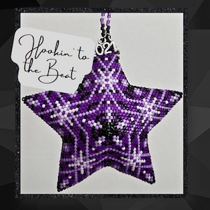 May include: Purple and white beaded star ornament with a silver charm that says "2021". The ornament is hanging from a silver string and has a white tag that says "Hookin' to the Beat".