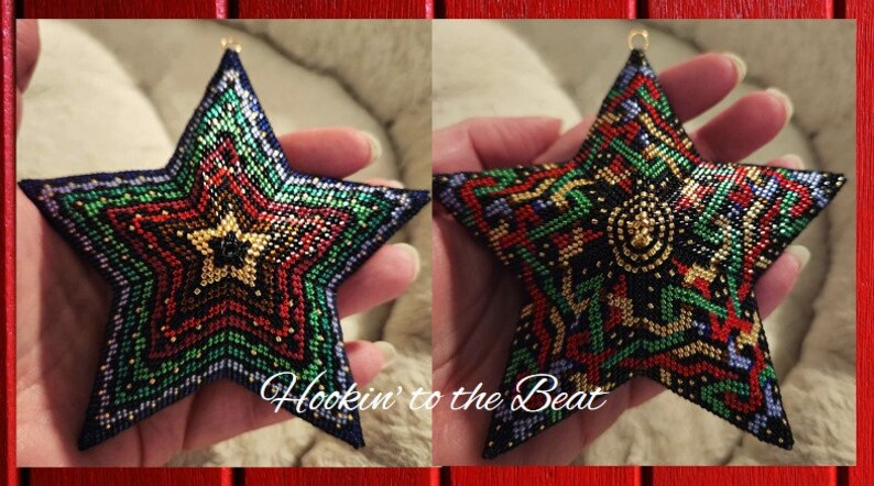 May include: A beaded star ornament with a multi-colored geometric pattern in shades of red, green, gold, and blue. The star is held in a hand and has a gold loop at the top for hanging.
