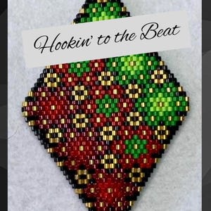 May include: A diamond-shaped beaded ornament featuring a geometric pattern in red, green, black, and gold glass beads. The text "Hookin' to the Beat" is printed across the center of the piece, which is constructed from small, uniform seed beads.