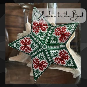 Puede incluir: Un adorno de estrella de cuentas verdes y rojas sobre un fondo blanco. La estrella es 3D y tiene un patrón geométrico. El texto "Hookin' to the Beat" está escrito en blanco sobre un fondo negro.