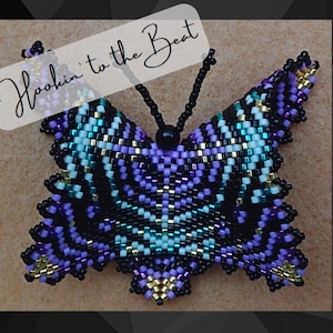 May include: A beaded butterfly with black, purple, white, gold, and teal accents. The butterfly is hanging from a black cord. The text "Hookin' to the Beat" is written in white on a black background.