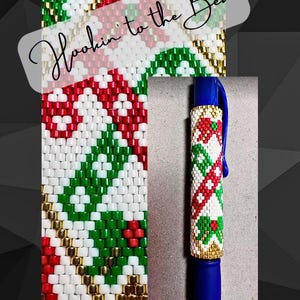May include: A blue pen with a beaded cover in red, white, and green colors. The beads are arranged in a geometric pattern. The text "Hookin' to the Beat" is written in white on a black background.