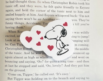 May include: A white cloud with a black outline and five red hearts. The cloud is shaped like a speech bubble. Inside the cloud is a black and white illustration of Snoopy, the beagle from the Peanuts comic strip, blowing a kiss. Snoopy is wearing his signature red collar. The text "I'm not saying there won't be an Accident... you. They're 1 till you're... was wildly oing to jump! umping will m coming, the middle ounced up - and went on - and then at last he stopped and said, 'Oo, lovely!' And they put him on the ground. 'Come on, Tigger,' he called out. 'It's easy.' But Tigger was holding on to the branch and saying to..."