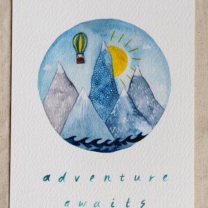 K&ouml;nnte beinhalten: Aquarellmalerei eines Hei&szlig;luftballons, der &uuml;ber Berge mit einer Sonne am Himmel fliegt. Der Text "adventure awaits" steht unter dem Bild.