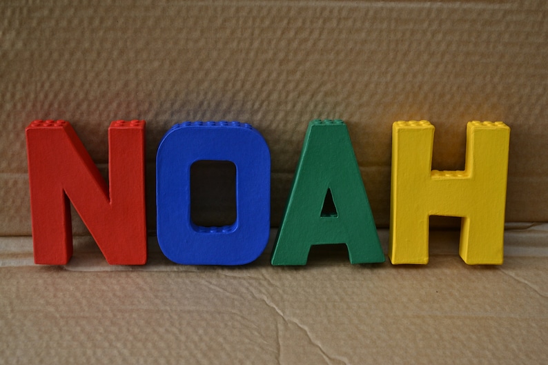 Hand painted papier mache lego letters spelling NOAH in red, blue, green & yellow