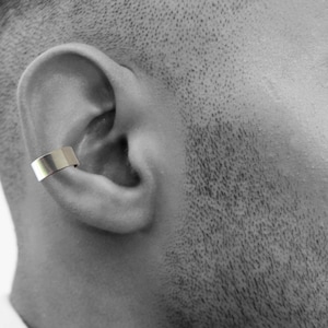 May include: A trio of cream-glazed ceramic mugs, each adorned with a hand-painted floral pattern. The designs feature blue, green, and yellow hues. The mugs have a classic, rounded form.