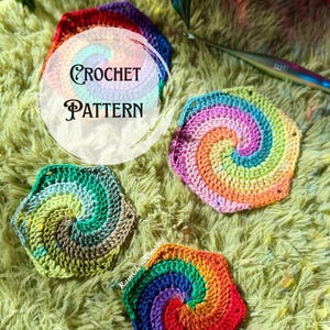 Op de afbeelding: Drie zeshoekige haakmotieven met een spiraalontwerp in levendige regenboogkleuren, samen met een zilveren haaknaald. De tekst CROCHET PATTERN is zichtbaar in het midden en de tekst RainCloudCrochet staat onderaan gedrukt.