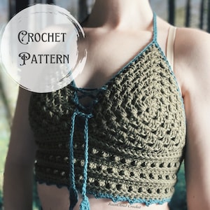 May include: A crochet top with a green and blue color scheme. The top has a lace-up front and a scalloped bottom. The text "RainCloud Crochet" is visible on the bottom of the top.
