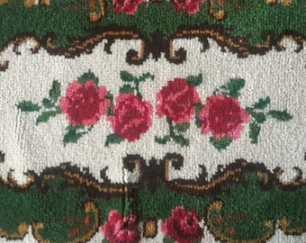 May include: A white and green rug with a floral design. The rug has a white center with a green border and a floral pattern in the center. The rug is made of a soft, plush material.