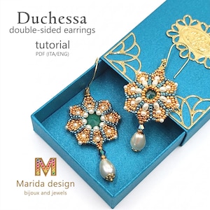 Può includere: Un tutorial in PDF per gli orecchini double-face Duchessa di Marida design. L'immagine mostra due orecchini floreali realizzati con perline dorate, verde ottanio e bianche, una pietra centrale verde e un pendente a goccia color perla.
