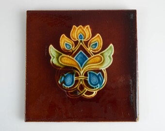 Antique 1900s Corn Bros Art Nouveau amber and blue flower pottery tile