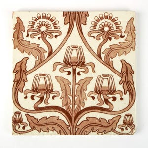 Peut inclure: Carreau de céramique carré avec un motif floral répétitif dans les tons marron et crème. Le motif présente des fleurs et des feuilles stylisées, créant un motif symétrique et décoratif. La tuile a une esthétique vintage ou antique.