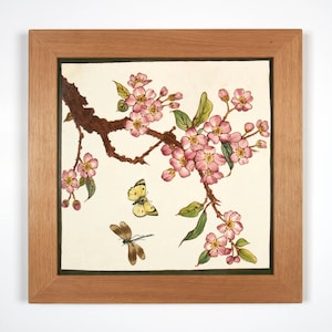 May include: A framed painting of a branch of pink blossoms with two butterflies, one yellow and one blue, on a white background.